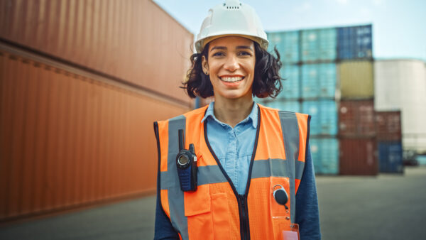 En kvinna står i varselväst på en byggarbetsplats